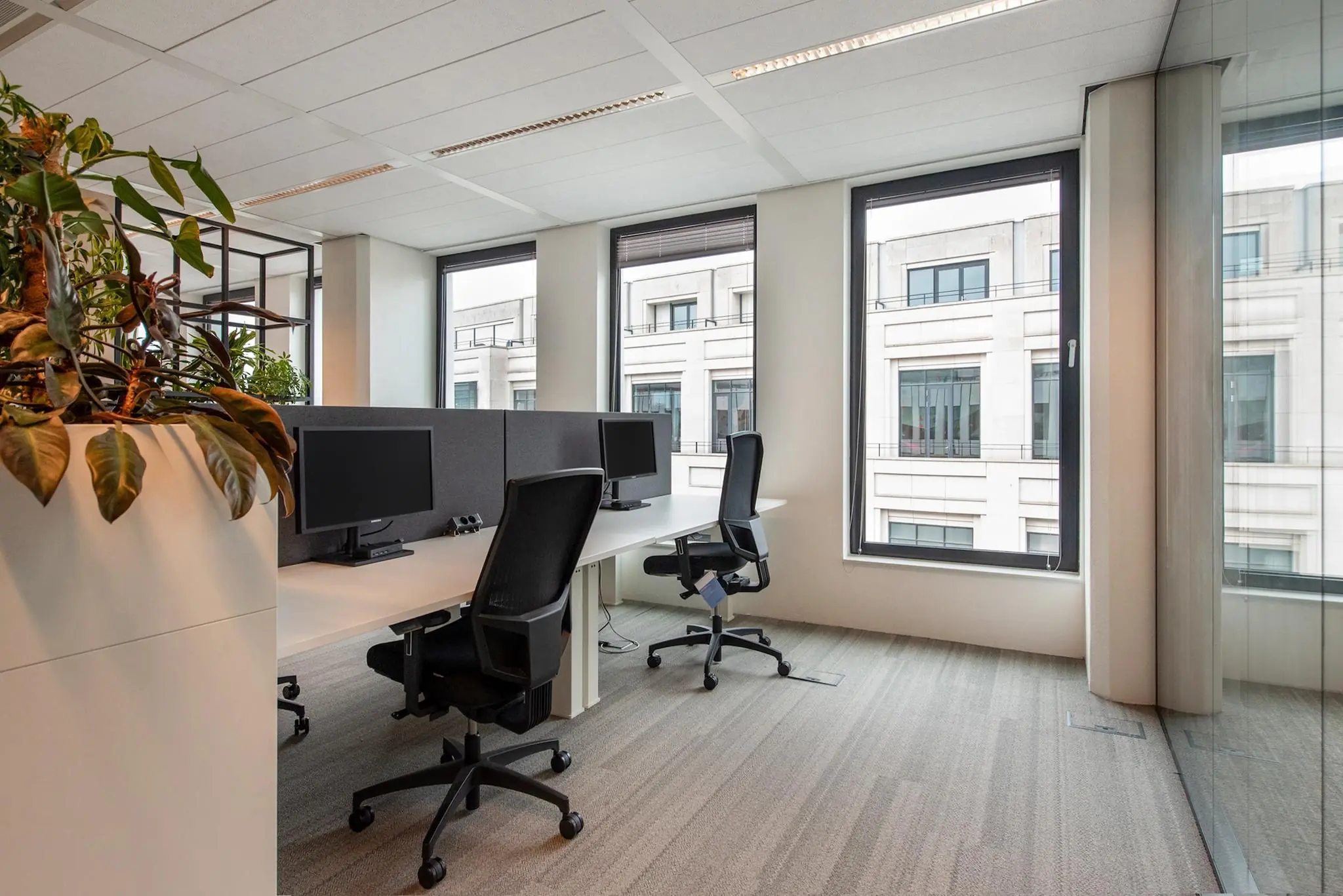 Modern kantoorinterieur met werkplekken en uitzicht op het gebouw aan de Grote Marktstraat.